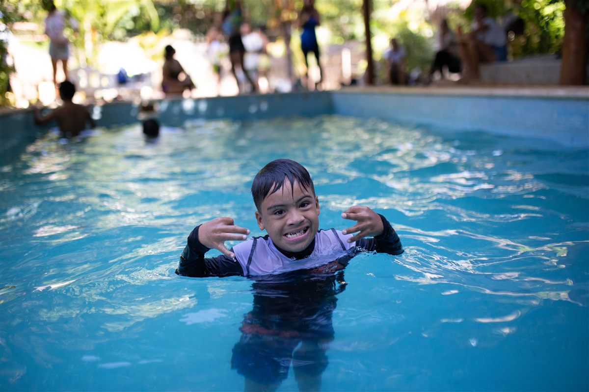 Niño sonriendo durante una actividad acuática inclusiva en la alberca